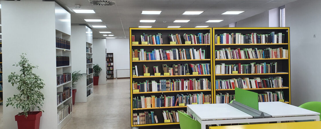 Unutrašnjost Gradske biblioteke Čačak sa policama ispunjenim knjigama, čitaoničkim stolovima i svetlim, modernim prostorom namenjenim ljubiteljima knjige i čitanja.