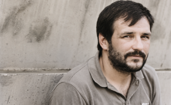 Đorđe Balašević u mladosti, crno-beli portret uz betonski zid.